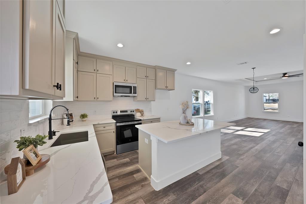 175 Harris Harbor Road East Tawakoni, TX 75472 - Photo 9 of 22 a kitchen with granite countertop a sink stainless steel appliances and white cabinets