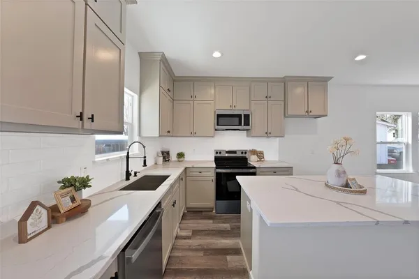 a kitchen with sink a stove and cabinets