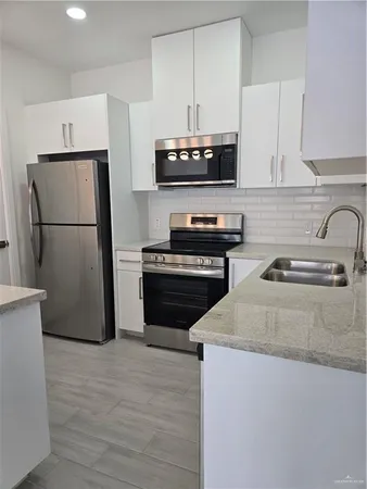 a kitchen with a refrigerator sink and stove