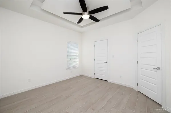 an empty room with a ceiling fan and window