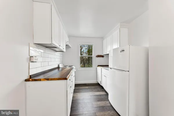 a kitchen with a refrigerator a stove and white cabinets