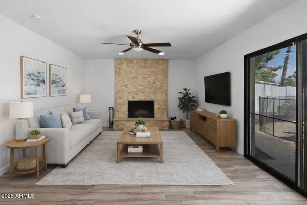 a living room with furniture a flat screen tv and a fireplace