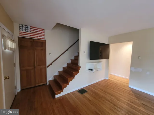 a view of a hallway with wooden floor and staircase