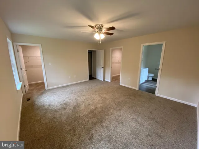 a view of a livingroom with a ceiling fan and window