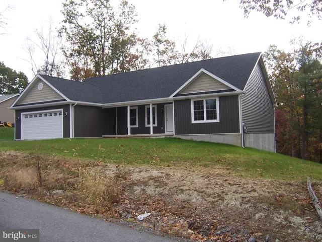 a view of a yard in front of a house with large tree