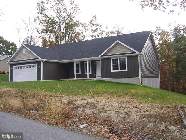 a view of a house with a yard and large tree