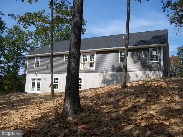 a view of a house with backyard and a tree
