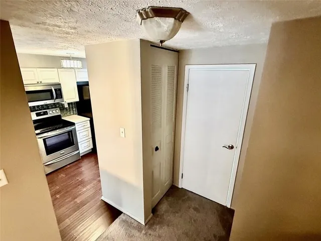 a view of a hallway with entryway and wooden floor