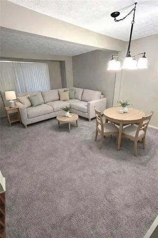 a living room with furniture and a chandelier