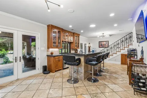 a kitchen with stainless steel appliances kitchen island granite countertop a refrigerator a stove a sink dishwasher with a dining table and chairs