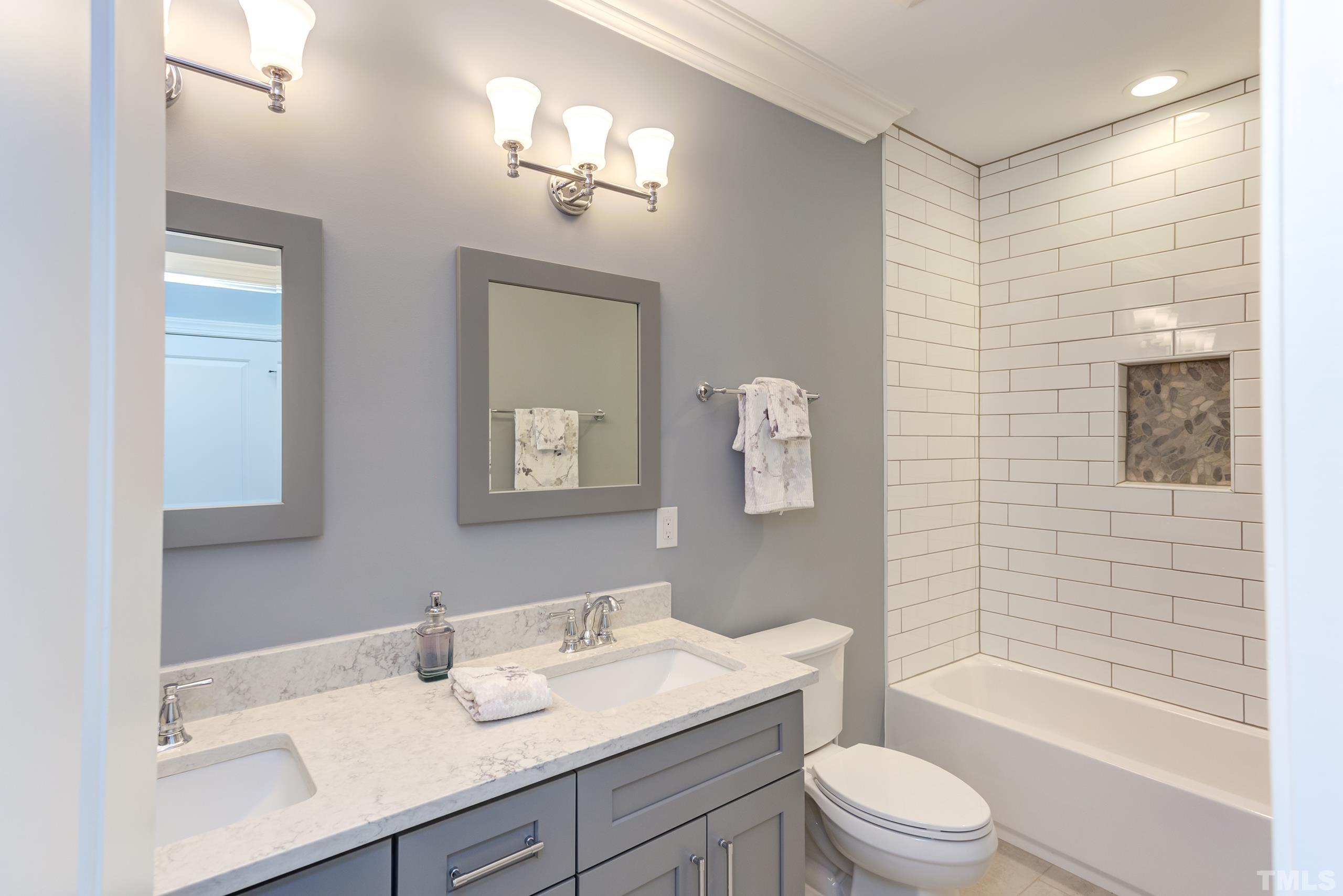 8009 Ghost Pony Trail Raleigh, NC 27613 - Photo 39 of 55 a bathroom with a sink a toilet a mirror and shower