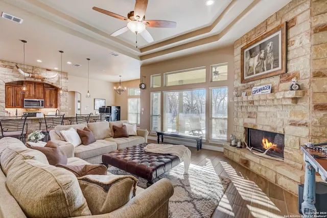 a room with stainless steel appliances kitchen island granite countertop a stove a sink a dining table and chairs with wooden floor