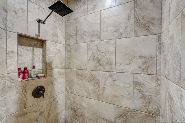 a bedroom with a bed a flat screen tv and a chandelier