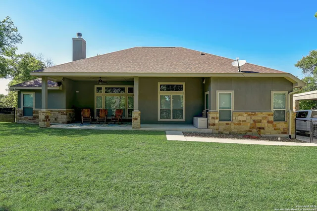 an aerial view of residential houses with outdoor space and trees