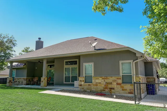 an aerial view of residential houses with outdoor space and trees