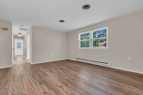 a view of an empty room with wooden floor