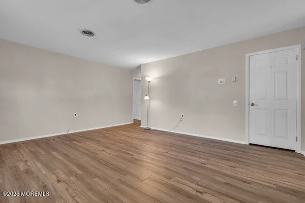 an empty room with windows and ceiling fan