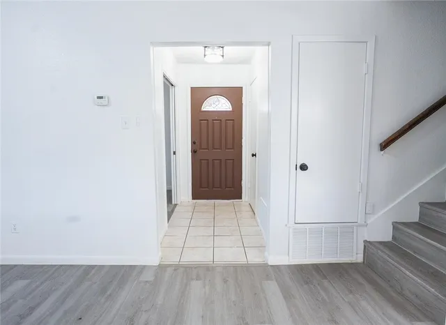 a view of a hallway with wooden floor and staircase