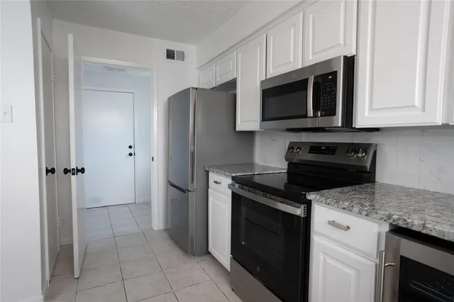 a kitchen with stainless steel appliances granite countertop a refrigerator stove and microwave