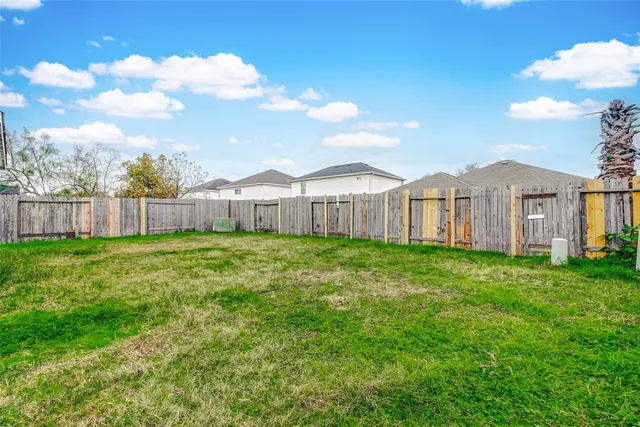 a view of a house with a big yard and large tree