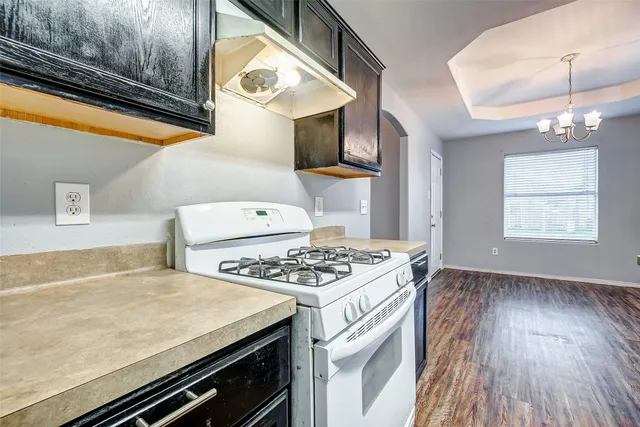a kitchen with a stove and a wooden floor