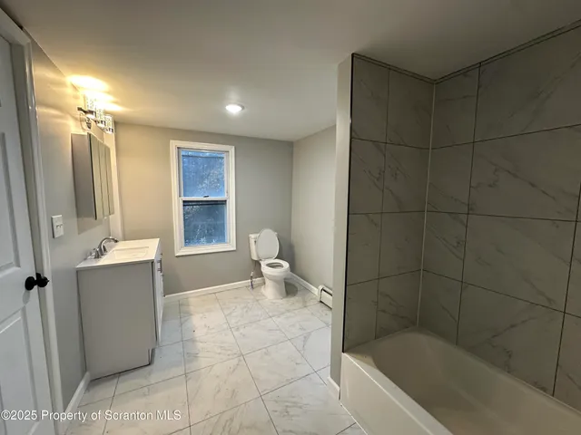 a bathroom with a bathtub a toilet a sink and mirror