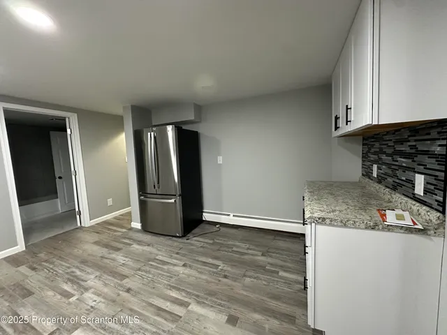 a kitchen with granite countertop a refrigerator and a stove