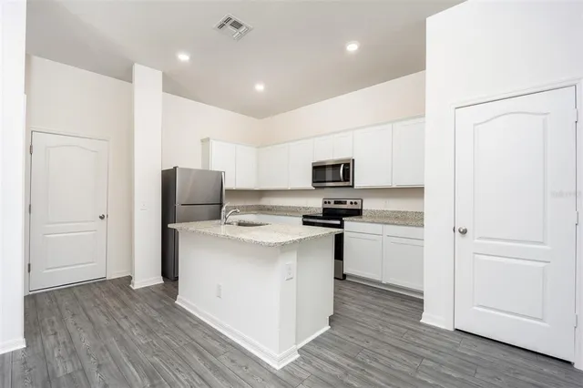 a kitchen with stainless steel appliances a refrigerator and a stove top oven
