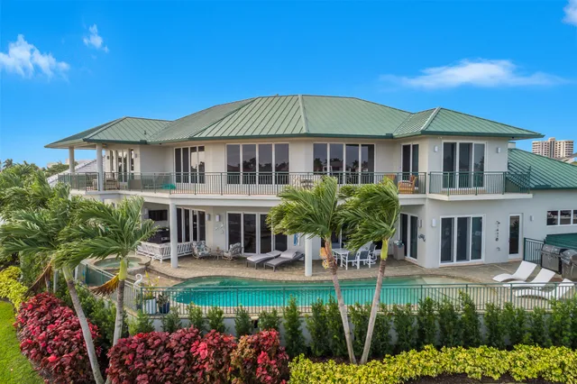 a view of a patio with couches table and chairs under an umbrella with potted plants