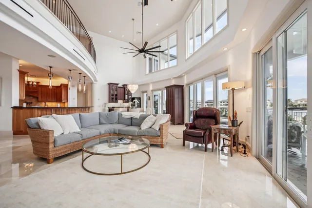 a living room with furniture a ceiling fan and a large window