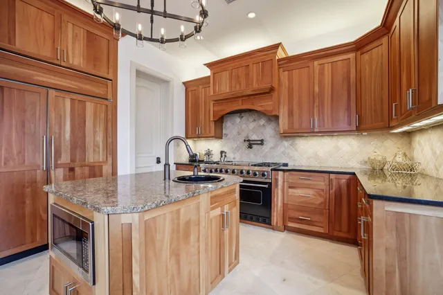 a kitchen with stainless steel appliances granite countertop a stove sink and cabinets