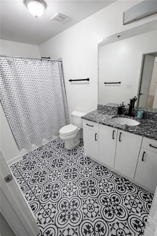 250 Pharr Road Northeast, Unit 601 Atlanta, GA 30305 - Photo 15 of 34 a bathroom with a granite countertop sink a toilet and a mirror