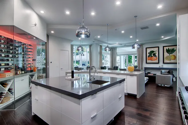 a kitchen with stainless steel appliances kitchen island granite countertop a refrigerator and a sink