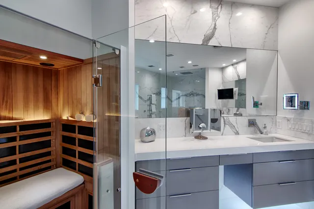 a bathroom with a tub a mirror and a shower