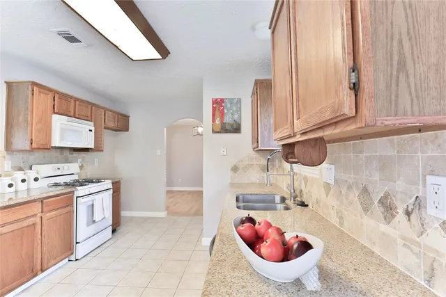 a bathroom with a granite countertop bathtub sink vanity mirror and toilet
