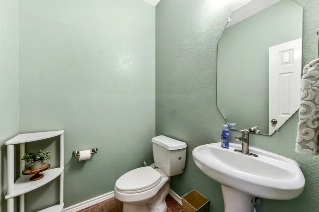 a bathroom with a sink a toilet and mirror
