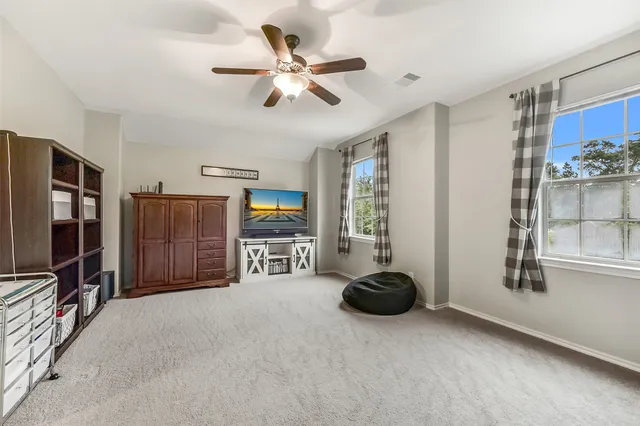 a living room with furniture a ceiling fan and a window