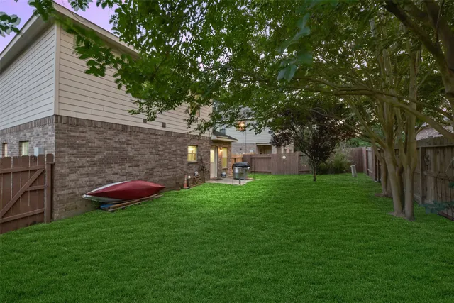 a view of a backyard with table and chairs and a large tree