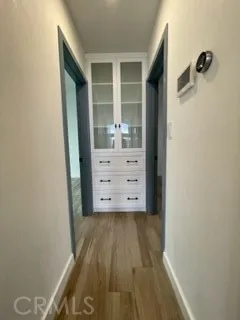 an empty room with wooden floor and entrance