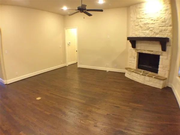a view of an empty room with furniture and windows