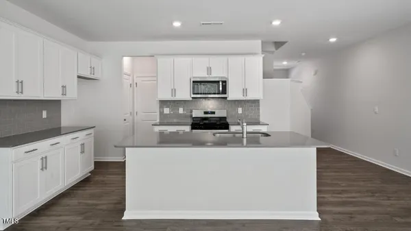 a large white kitchen with stainless steel appliances