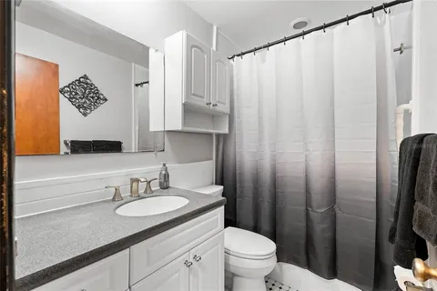 a bathroom with a granite countertop sink toilet and shower