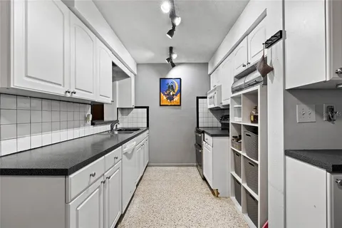 a kitchen with stainless steel appliances granite countertop a sink and a stove