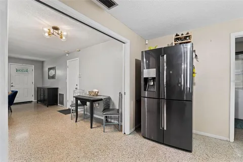 a kitchen with a refrigerator a microwave and dining table