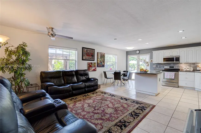a living room with furniture and a dining room with kitchen view