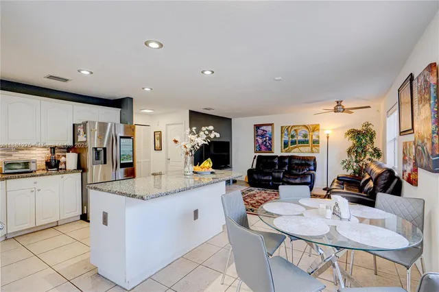 a kitchen with stainless steel appliances kitchen island granite countertop a sink and cabinets