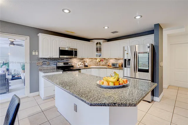 a kitchen with stainless steel appliances granite countertop a sink a stove and a refrigerator