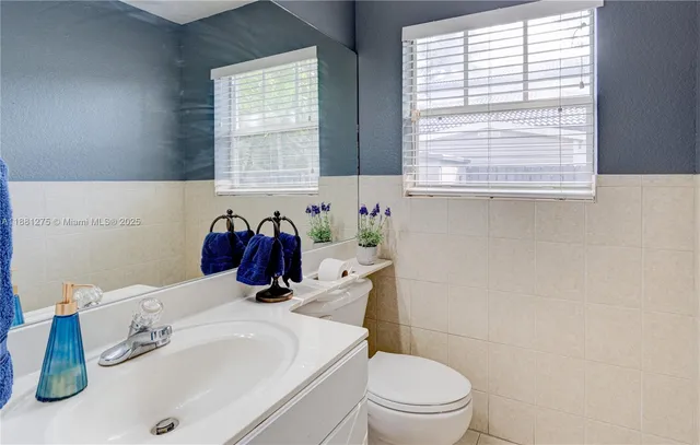 a bathroom with a sink a toilet and a window