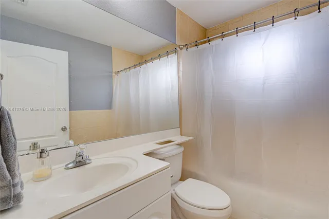 a bathroom with a sink vanity mirror and toilet
