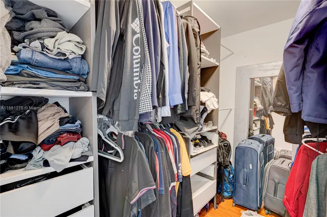 a view of walk in closet with clothes and shoes
